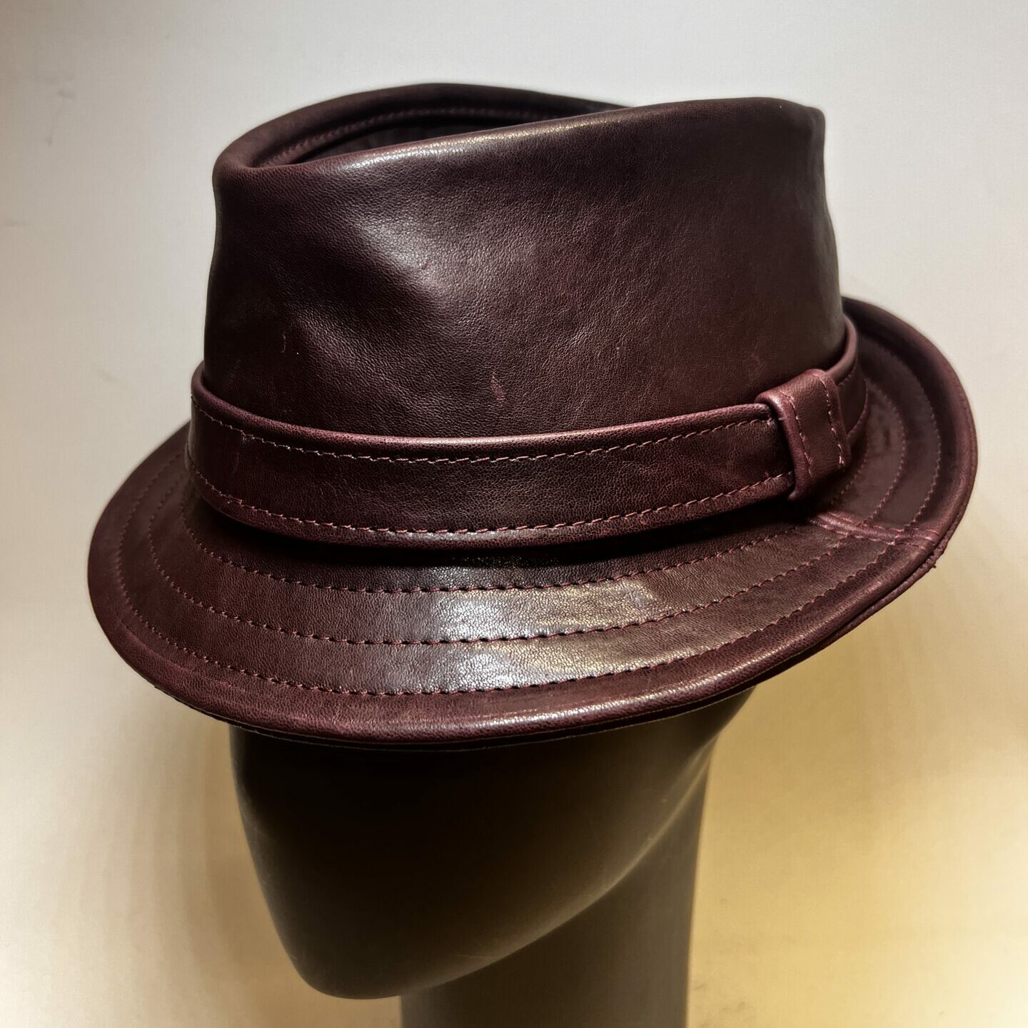 Red Nappa Leather Pinch Trilby Hat on grey mannequin